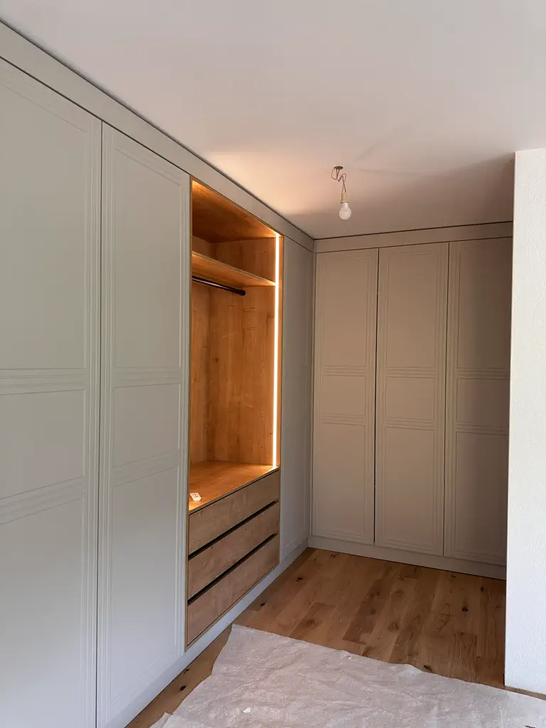 Einbauschrank mit grifflosem Design, Holzinnenraum und indirekter LED-Beleuchtung