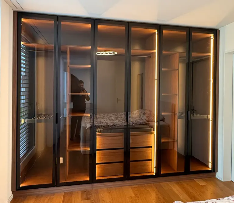 Moderner Glas-Kleiderschrank mit Nussbaumholz und integrierter LED-Beleuchtung im Schlafzimmer